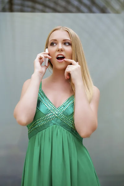 Ung vacker flicka i den gröna klänningen talar i mobiltelefon — Stockfoto