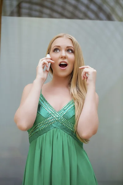 Young beautiful girl in the green dress talking on cell phone — Stock Photo, Image