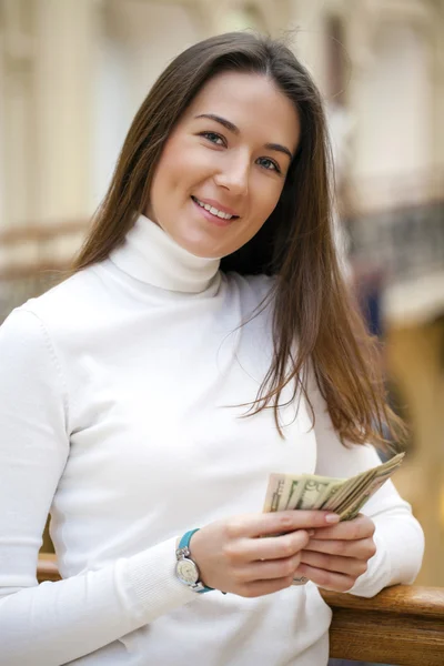 Brunette female holding and showing dollars — Stock Photo, Image