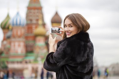 Genç güzel kadın turist üstünde hareket eden telefon fotoğraf çekmek 