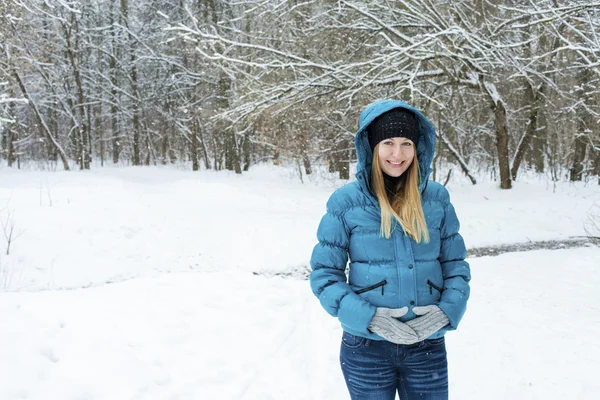 Winter vrouw in rest sneeuw park. Meisje in een turquoise veer-bed — Stockfoto