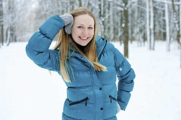 Winter woman in rest snow park. Girl in a turquoise feather bed Royalty Free Stock Photos