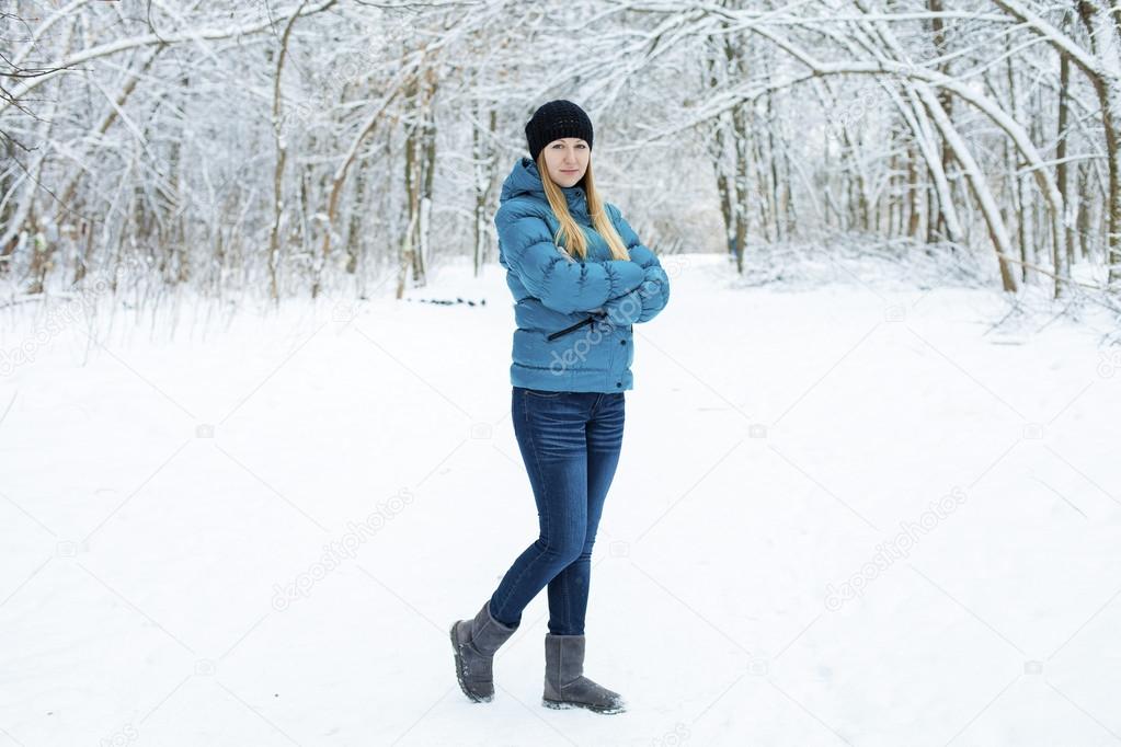 Winter woman in rest snow park. Girl in a turquoise feather bed 