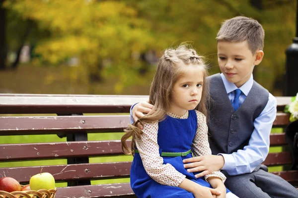 Sad little girl is sitting on the bench, outdoor shoot — Stock Photo, Image