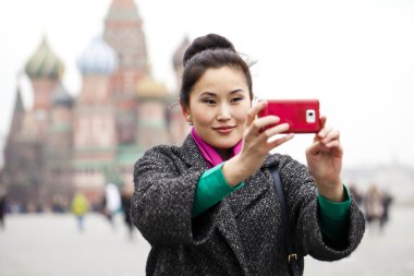 Genç güzel kadın turist üstünde hareket eden telefon fotoğraf çekmek