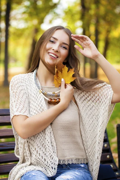 Belle fille reposant sur un banc dans le parc d'automne — Photo