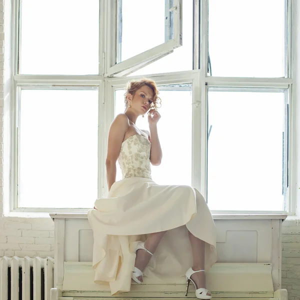 Encantadora chica hermosa pelo rojo joven en un vestido de encaje blanco sentarse — Foto de Stock