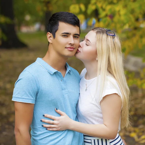 Happy young couple kissing outdoor in the autumn park — Stock Photo, Image