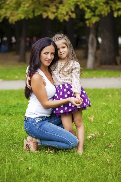 Beautifal little girl and happy mother in the autumn park — Stock Photo, Image