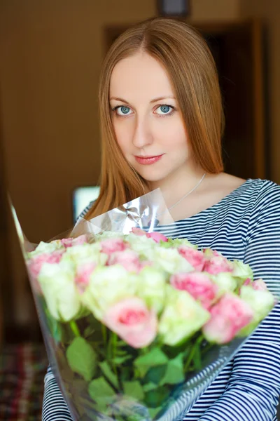 Portret van een mooie jonge vrouw met een boeket van rode rozen — Stockfoto