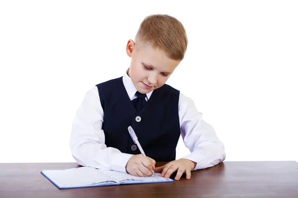 Caucasiano menino da escola em sua mesa em fundo branco com cópia s — Fotografia de Stock