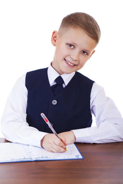 Caucasiano menino da escola em sua mesa em fundo branco com cópia s — Fotografia de Stock