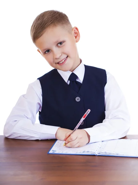 Kavkazská školy chlapec u stolu na bílém pozadí s kopií s — Stock fotografie