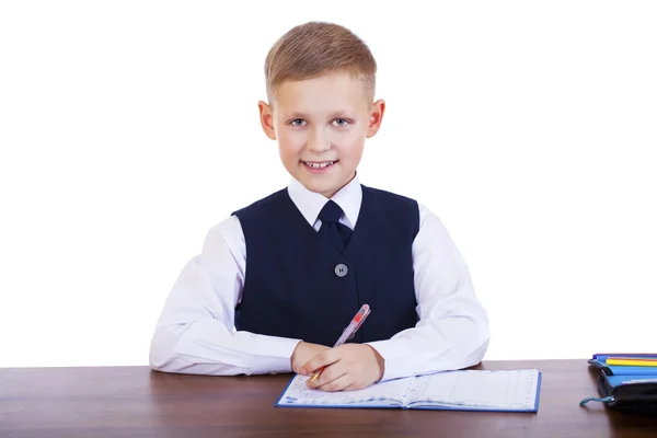 Caucasiano menino da escola em sua mesa em fundo branco com cópia s — Fotografia de Stock