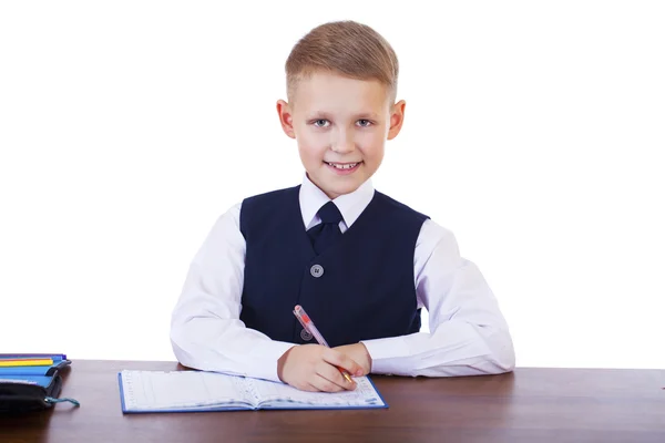 Caucasiano menino da escola em sua mesa em fundo branco com cópia s — Fotografia de Stock