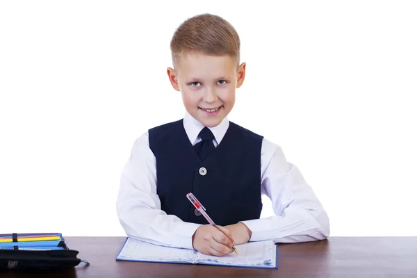 Kaukasische school jongen achter zijn Bureau op witte achtergrond met kopie s Stockafbeelding