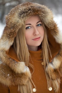 Bir kış park arka plan üzerinde mutlu sarışın genç kadın