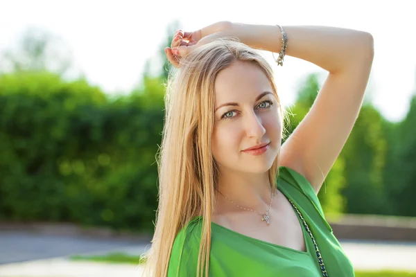 Jovem mulher bonita em vestido verde posando ao ar livre em ensolarado nós — Fotografia de Stock