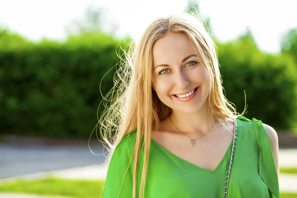 Joven hermosa mujer en vestido verde posando al aire libre en soleado nosotros —  Fotos de Stock