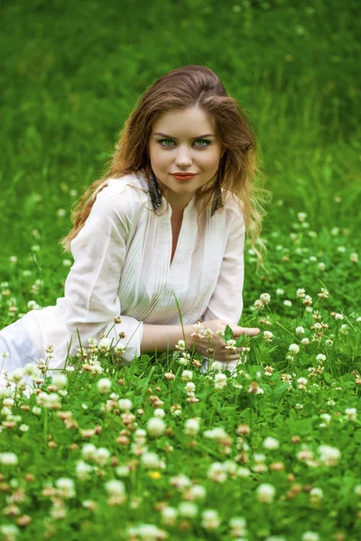 緑の牧草地に若いブロンドの女性 — ストック写真