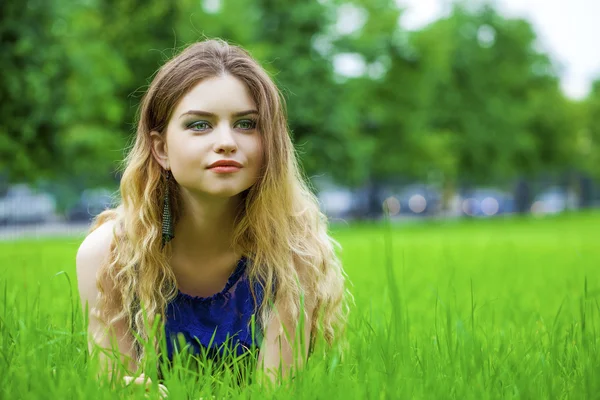 緑の牧草地に若いブロンドの女性 — ストック写真