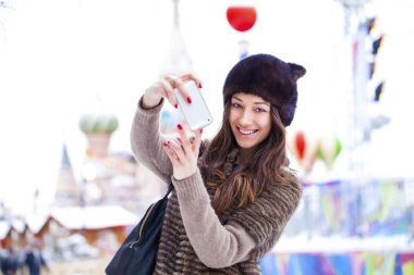 Genç güzel kadın turist üstünde hareket eden telefon fotoğraf çekmek