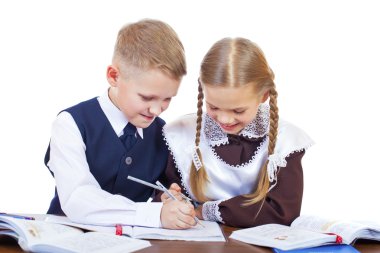 İlköğretim okulu öğrencileri birkaç masa başında oturmak