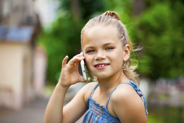 Yeşil park summe karşı cep telefonuyla konuşan küçük kız — Stok fotoğraf