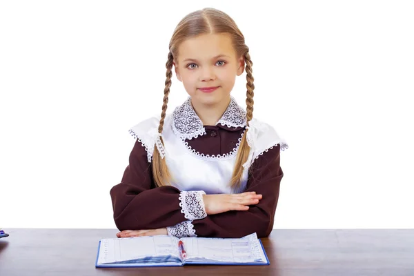 Jonge mooie schoolmeisje zitten aan een bureau — Stockfoto