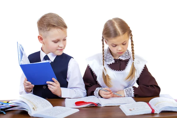 Um par de alunos do ensino fundamental sentam-se em uma mesa — Fotografia de Stock