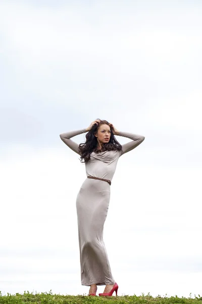 Junge Frau im sexy langen grauen Kleid — Stockfoto