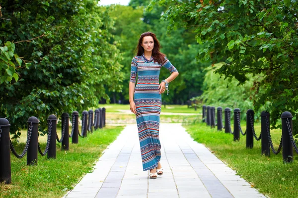 Beautiful young woman in colorful dress — Stock Photo, Image