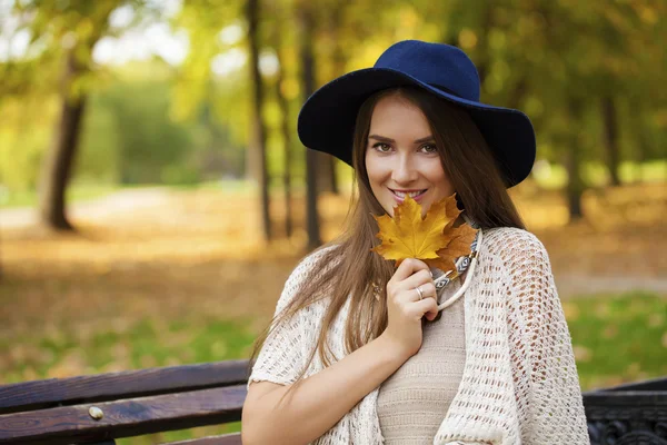 Sonbahar parkta bir bankta oturan güzel kız — Stok fotoğraf