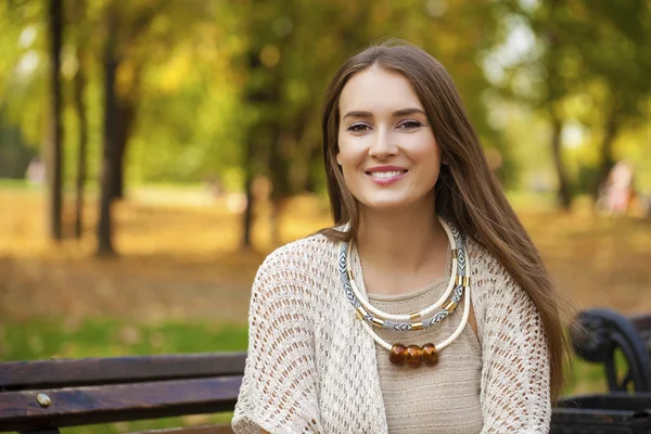 Belle fille reposant sur un banc dans le parc d'automne — Photo