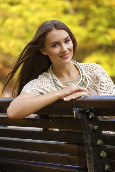 Hermosa chica descansando en un banco en el parque de otoño —  Fotos de Stock