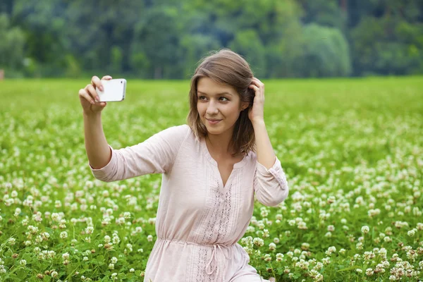 Young beautiful blonde woman photographing themselves on a cell — Stock Photo, Image