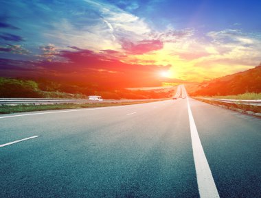 asfaltweg en zonsondergang