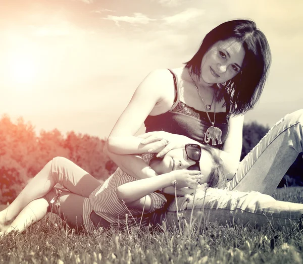 Mère et fille assises sur l'herbe — Photo