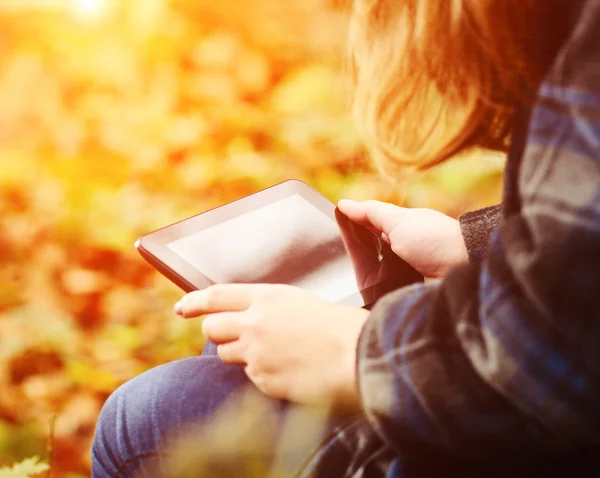 Mulher com tablet no parque de outono — Fotografia de Stock