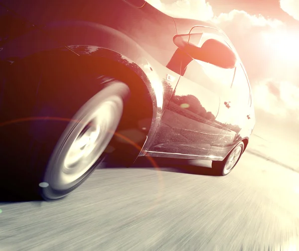 Side view of black car in turn Stock Photo