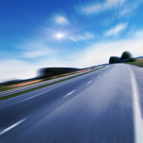 Autobahnverkehr bei Sonnenuntergang in der Nähe von Feldern — Stockfoto