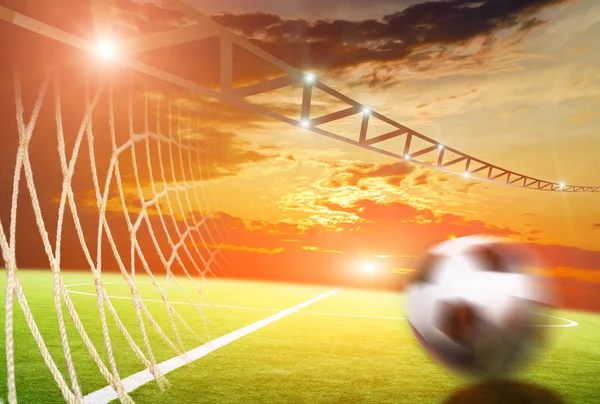 Bola de futebol no pôr do sol fundo — Fotografia de Stock