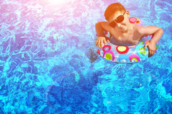 Küçük çocuk havuzda yüzüyor. — Stok fotoğraf