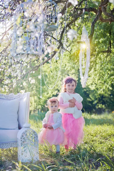 Kleine Schwestern im blühenden Garten — Stockfoto