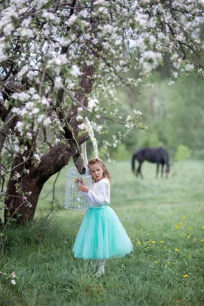 Kleines Mädchen im Frühjahrsblütengarten — Stockfoto