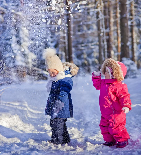 Двое детей играют со снегом — стоковое фото