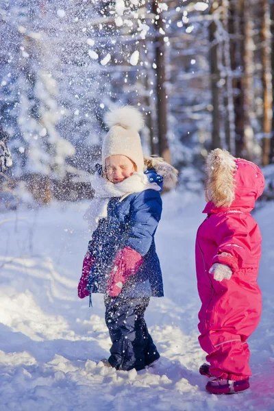 Двое детей играют со снегом — стоковое фото
