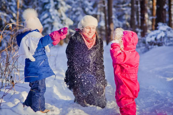 Mãe e duas crianças brincando com neve — Fotografia de Stock