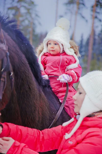 Baby girl jízda na koni v zimě — Stock fotografie