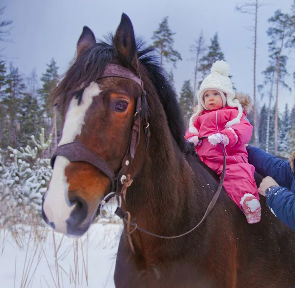 Baby girl jízda na koni v zimě — Stock fotografie